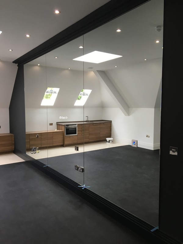 Frameless glass partition in loft conversion by Mitcham glaziers