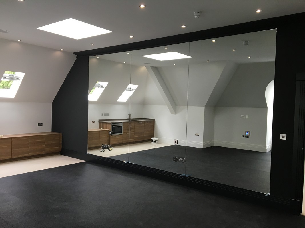 Frameless glass wall dividing loft conversion in Mitcham